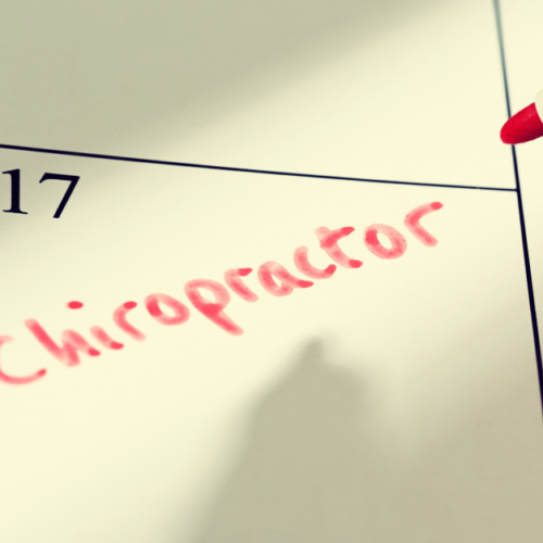 Close-up of a calendar with 'Chiropractor' written in red marker on the 17th, indicating an appointment.